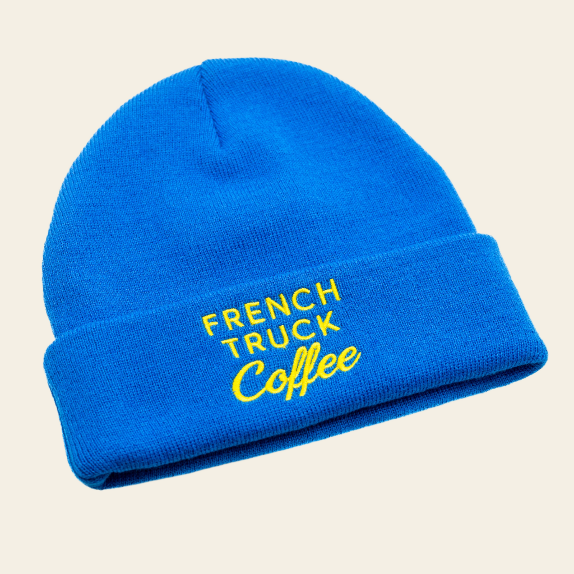 Blue knit beanie with white French Truck Coffee logo, ideal for cold days